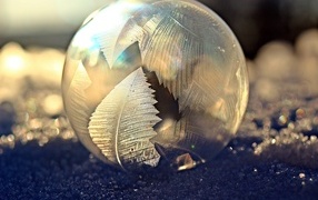 Морозный рисунок на мыльном пузыре на снегу зимой