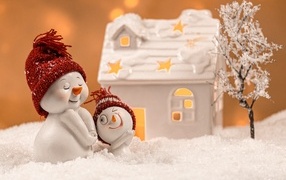 Игрушечные снеговики с домиком на снегу