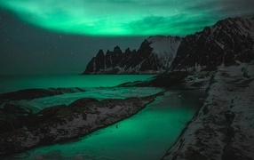 Зеленое полярное сияние над горами в Норвегии