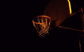 Баскетбольное кольцо в лучах света ночью