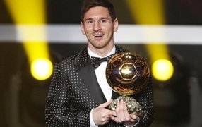 Football player Lionel Messi with a golden ball in his hands