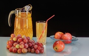Виноград и яблоки на столе с соком