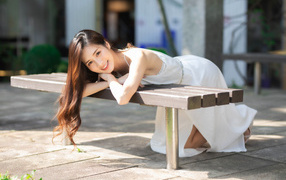 Девушка азиатка в белом платье с милой улыбкой
