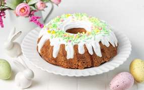Sweet Easter cake with eggs and flowers on the table