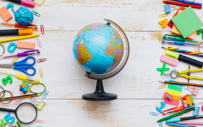 Globe on wooden background with stationery items
