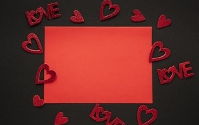 Red sheet of paper on a black background with hearts, template for a postcard