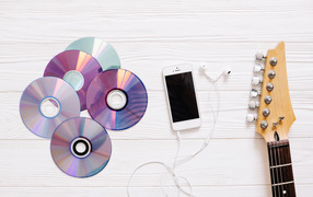 Discs with phone and guitar on white background
