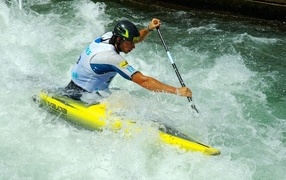 A man on a kayak goes down a stormy river
