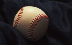 Baseball ball on black fabric