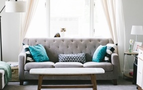 Серый диван с деревянным столом в комнате