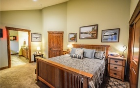 Большая деревянная двуспальная кровать в комнате
