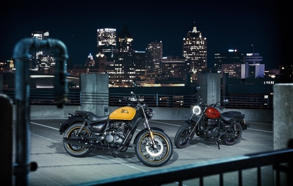 Two Royal Enfield Meteor 350 motorcycles with the city in the background