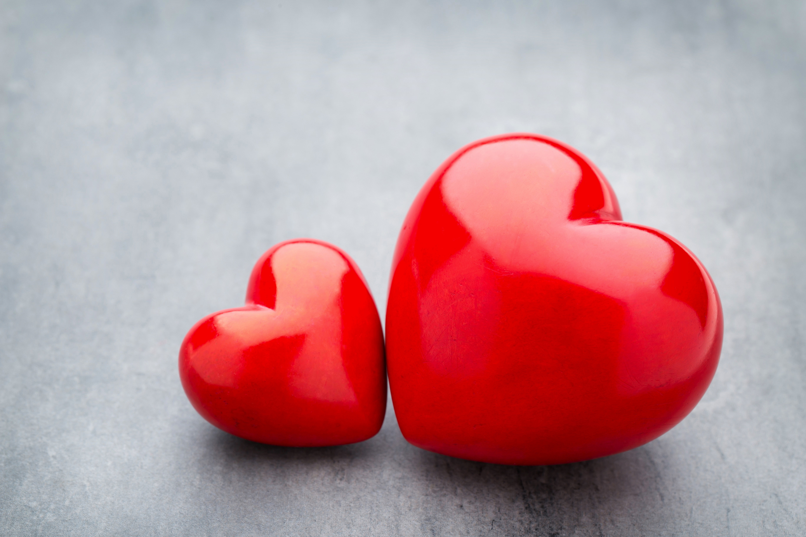 Большое и маленькое красное сердце на сером столе обои для рабочего